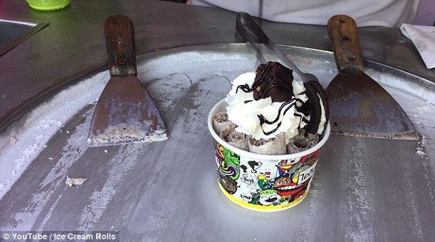 After placing the rolls inside a cup, this Thai street vendor tops the creation with another Oreo biscuit, whipped cream and a mini brownie