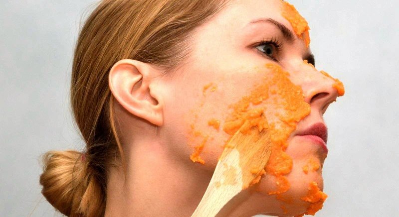 Девушка наносит на кожу маску из моркови