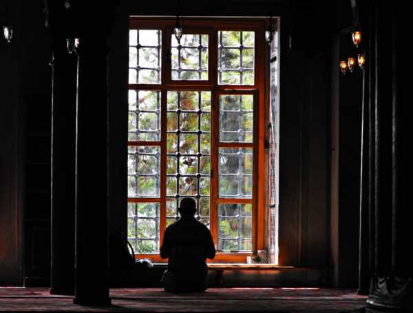 Мужчина молится у окна