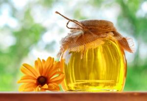 fragrant honey in glass jar with flower